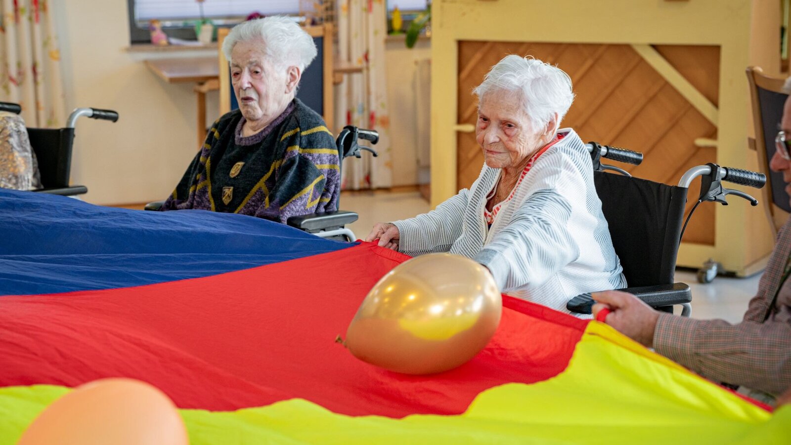 Bewohnerinnen mit Schwungtuch und Luftballons